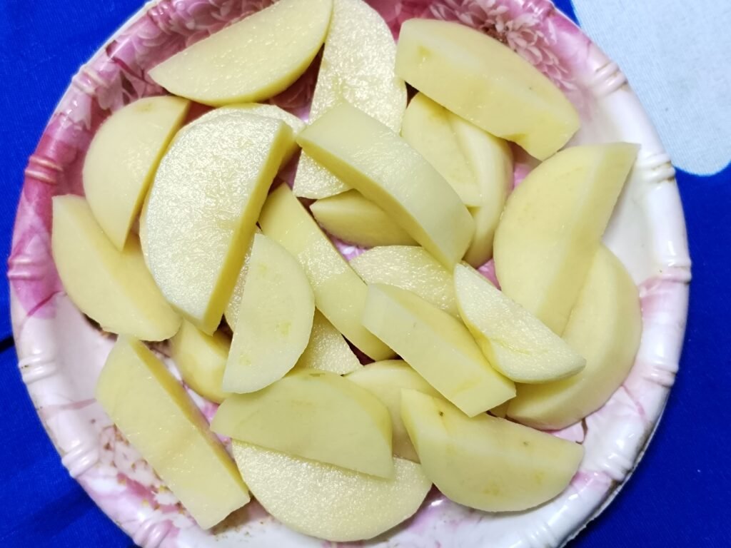 peeled and cut potato pieces on a plate ready for yellow rice with potato recipe