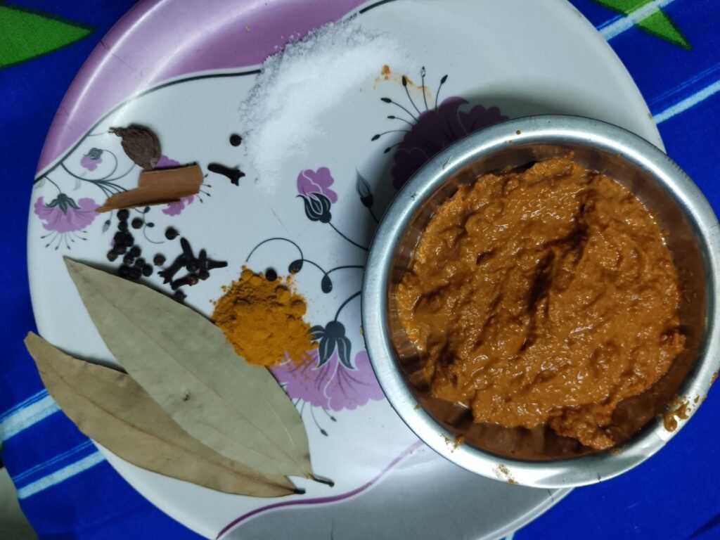 ground spice paste in steel bowl with whole spices salt turmeric bay leaf and cinnamon arranged on the side for taro beef stew recipe
