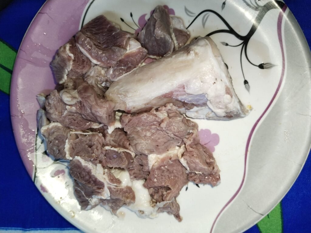 raw bone-in beef pieces on a plate ready to be washed and cooked for taro beef stew recipe