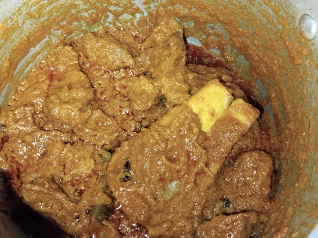 beef pieces in thick absorbed spice masala after four whistles in pressure cooker ready for Taro to be added