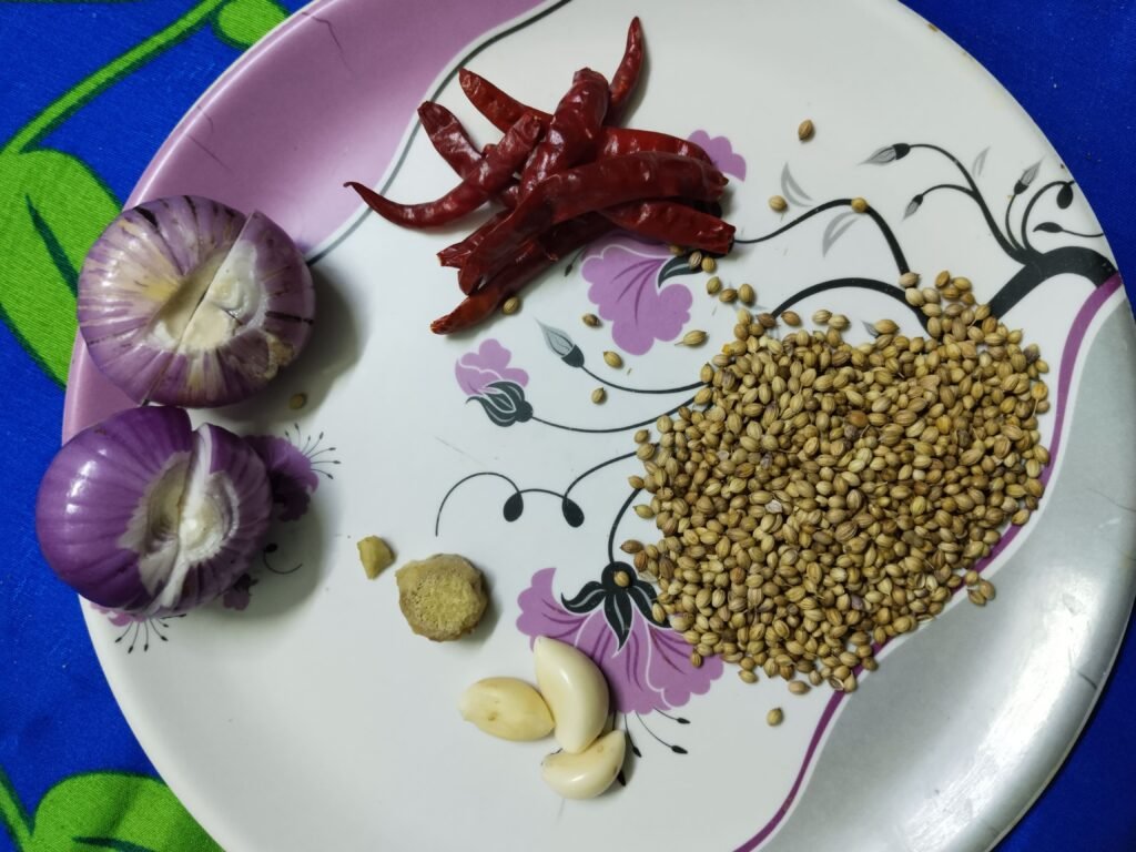bottle gourd balls recipe spice plate with halved onions dried red chilies coriander seeds garlic and ginger piece before grinding)