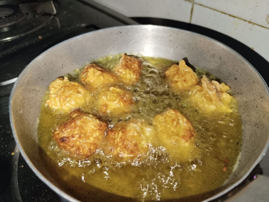 bottle gourd balls frying in oil in pan turning golden brown for bottle gourd balls