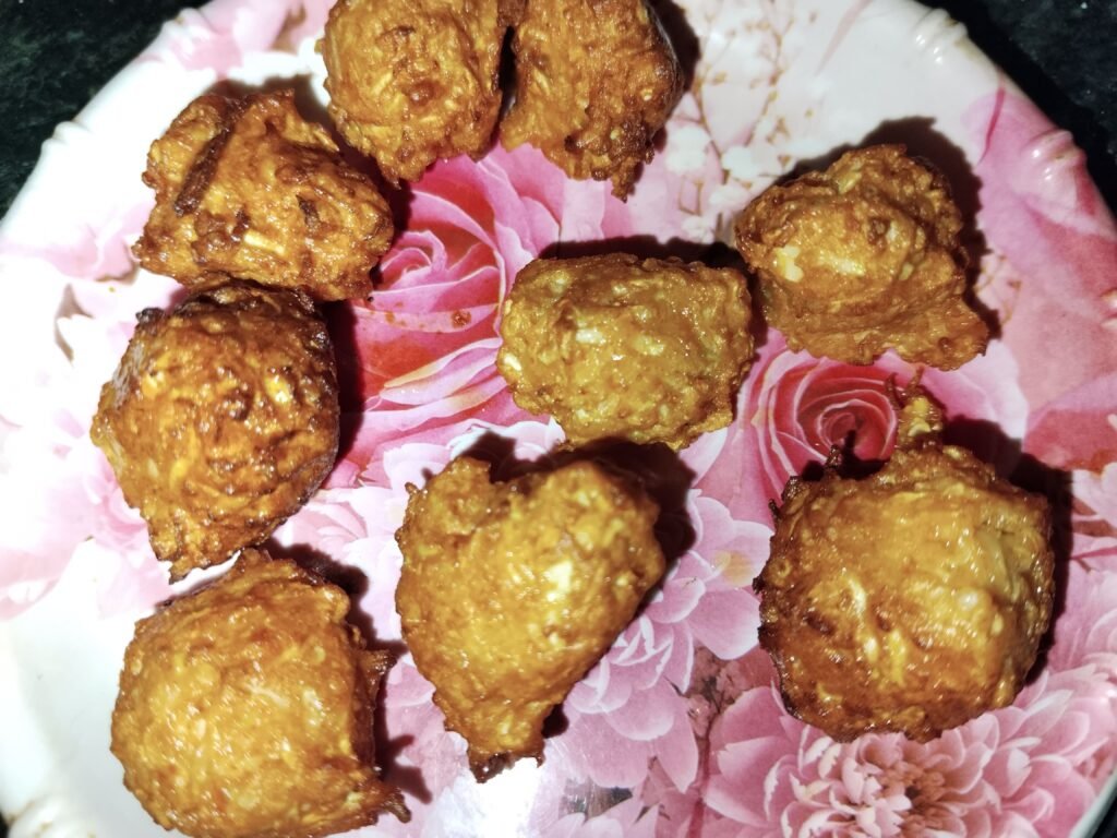 golden brown fried bottle gourd balls set on plate ready to add to gravy