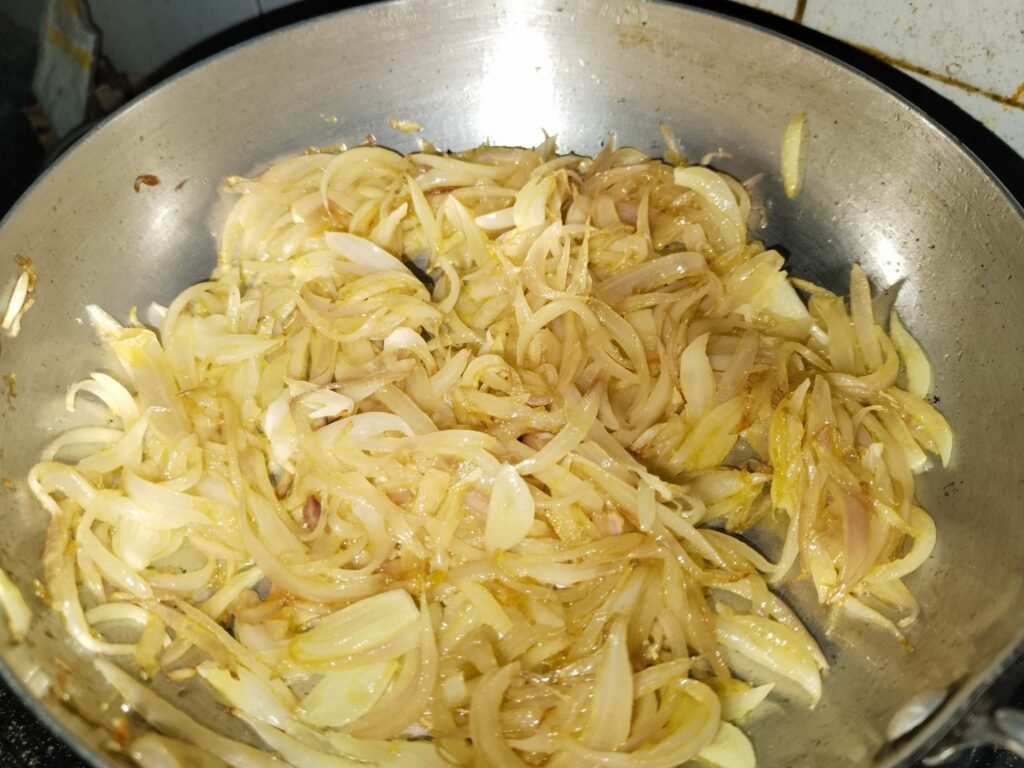 sliced onions frying alone in oil in pan early stage for white creamy chicken recipe paste base