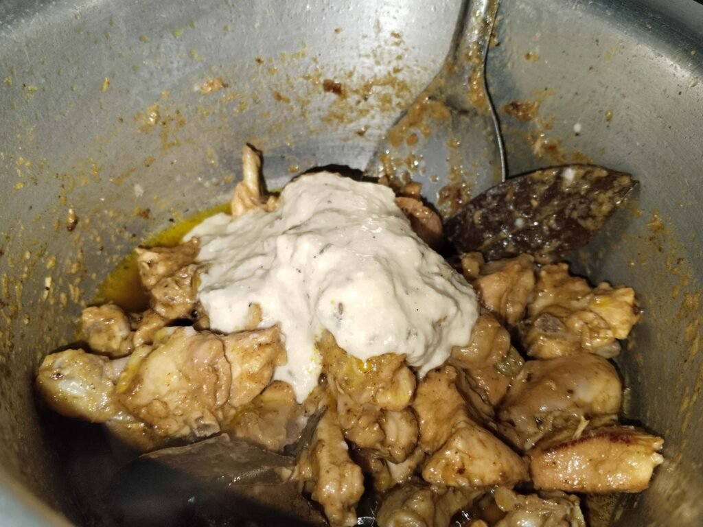 Chicken in pot with white marinade paste added back for final cooking stage