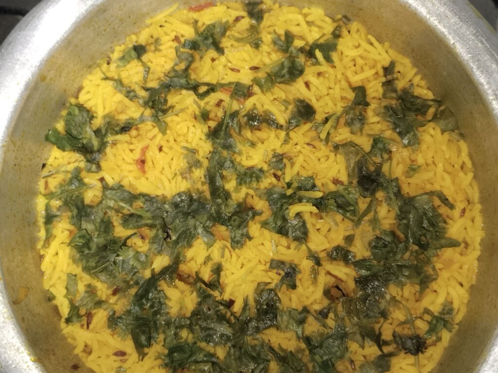 yellow rice recipe with potato cooked in one pot and garnished with fresh coriander leaves