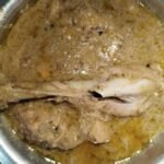 white creamy chicken recipe finished in pale golden creamy gravy in pot ready to serve